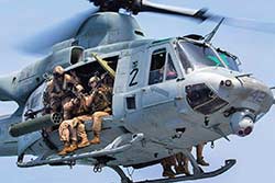 US Marine Corps snipers armed with Mk 11 Mod 0 rifles provide overwatch from a UH-1N